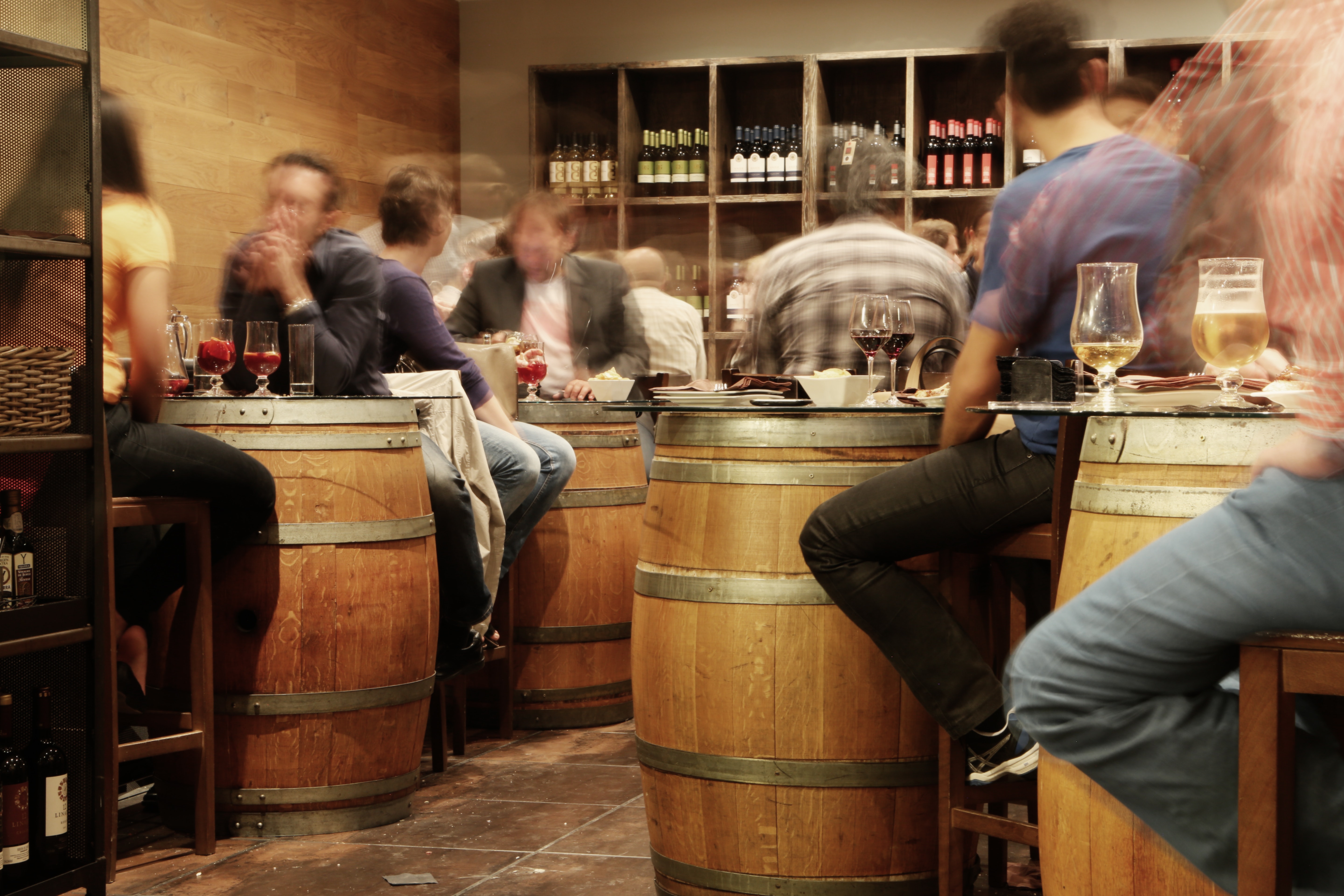 Guests sitting at wine barrels in tasting room